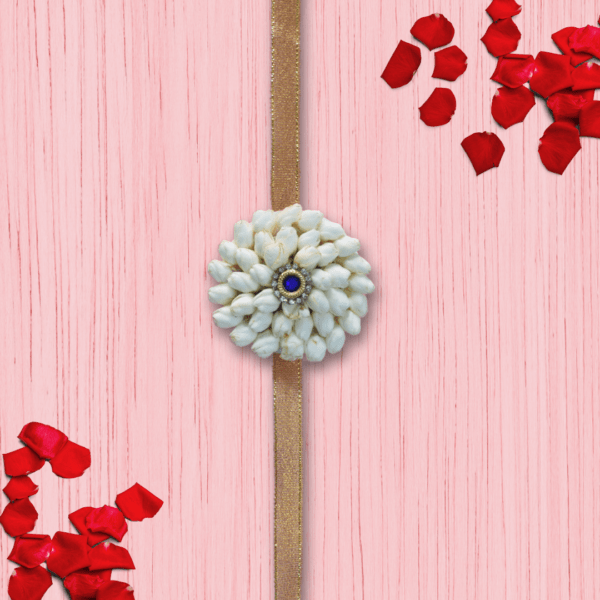 Eco-friendly rakhi made of white jasmine buds with blue gemstone center on golden ribbon,