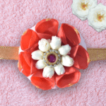 Floral rakhi with orange rose petals and arabian jasmine centerpiece