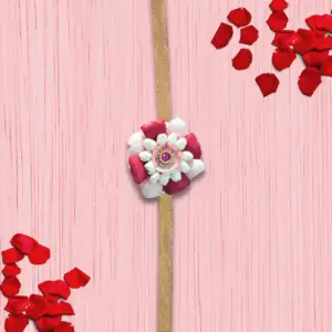 Eco-friendly rakhi featuring white jasmine buds, red and pink rose petals, with pink gemstone centerpiece on golden ribbon