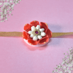 Floral rakhi with orange rose petals and arabian jasmine centerpiece