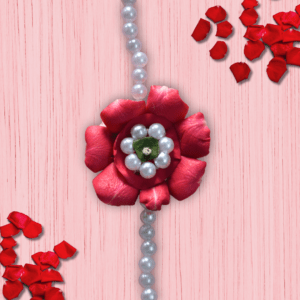 Eco-friendly rakhi featuring a red rose made of fresh petals with pearl-like center and green leaf, on a pearl bead strand