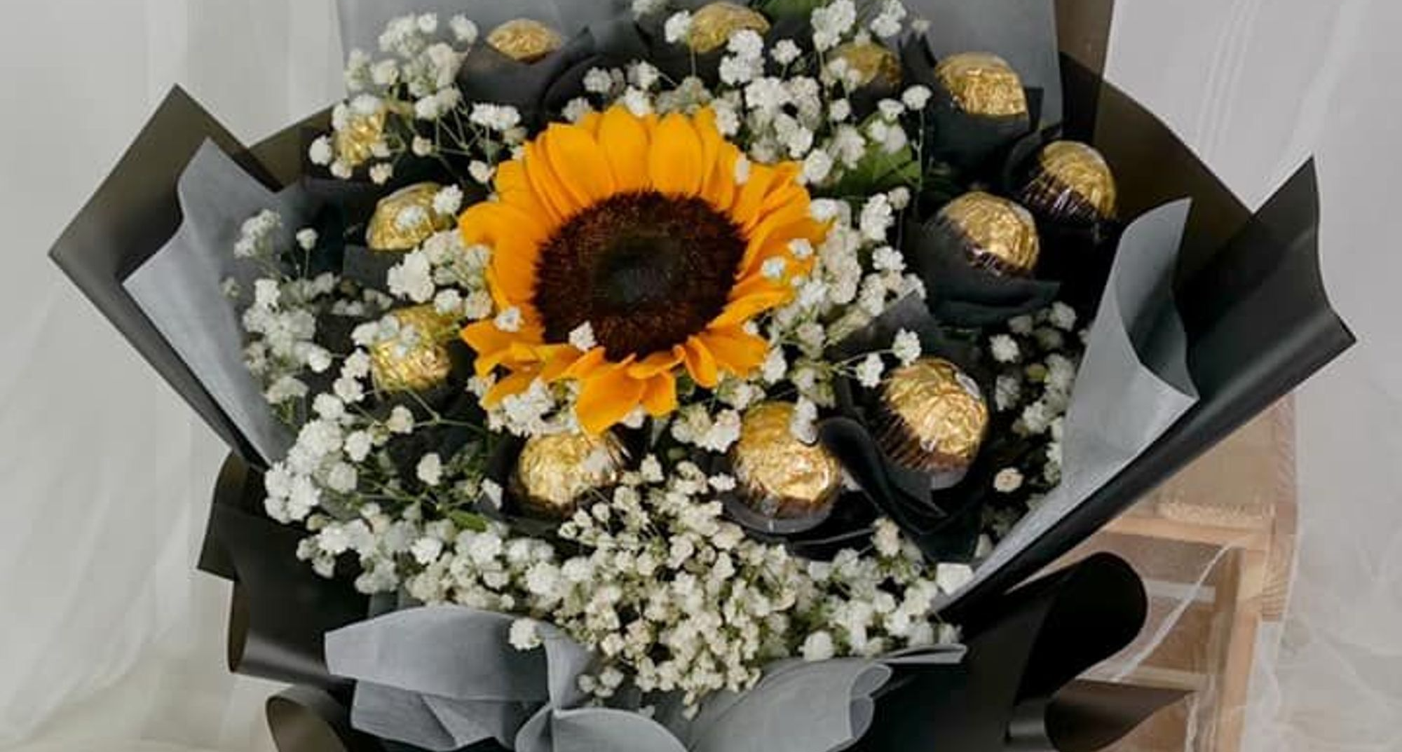 Chocolate bouquet made with Ferrero Rocher and sunflower wrapped in a premium black paper