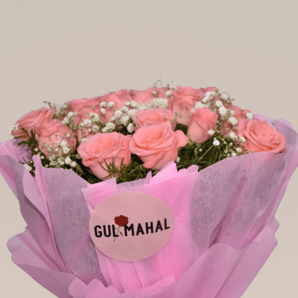 A bouquet of soft pink roses surrounded by baby's breath and greenery, wrapped in a pink paper with a delicate bow.