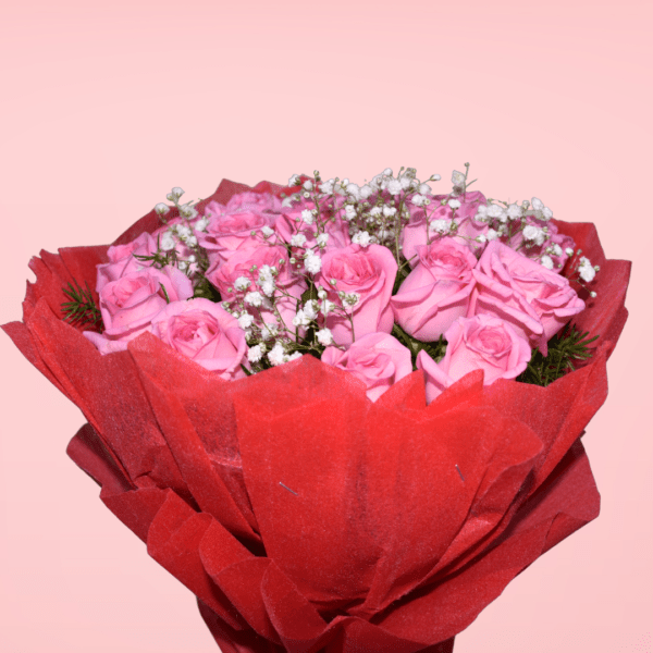 A bouquet of fresh pink roses surrounded by baby's breath and wrapped in red paper, perfect for special occasions.