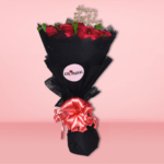 A premium bouquet of vibrant red roses with green foliage, wrapped in black paper, ideal for romantic gestures and special occasions.