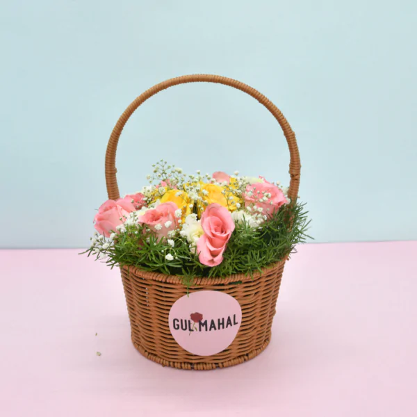 Gulmahal wicker basket filled with pink roses, yellow daisies, and baby's breath