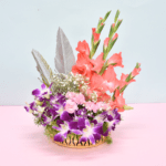 Tropical flower basket with coral gladioli, purple orchids, pink carnations, and silver feathers in a golden container