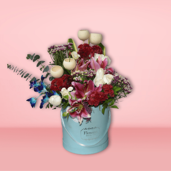 A beautiful floral bouquet featuring a variety of vibrant blooms, including red carnations, pink lilies, purple statice, and white tulips, presented in a charming turquoise vase