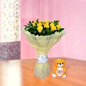 Vibrant bouquet of 20 yellow roses with greenery in black and white vase