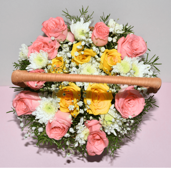 Gulmahal wicker basket filled with pink roses, yellow daisies, and baby's breath