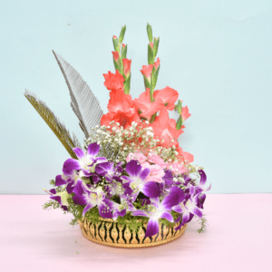 Tropical flower basket with coral gladioli, purple orchids, pink carnations, and silver feathers in a golden container