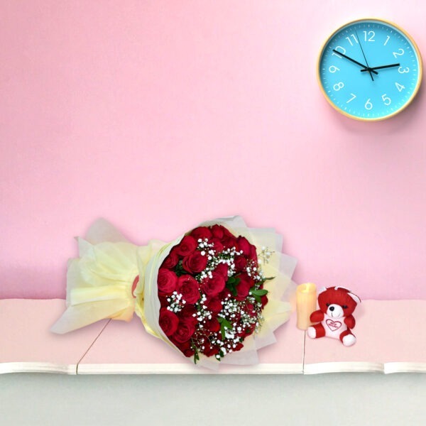 A bouquet of fresh red roses with baby's breath wrapped in cream paper, displayed against a pink background.