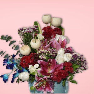 A beautiful floral bouquet featuring a variety of vibrant blooms, including red carnations, pink lilies, purple statice, and white tulips, presented in a charming turquoise vase