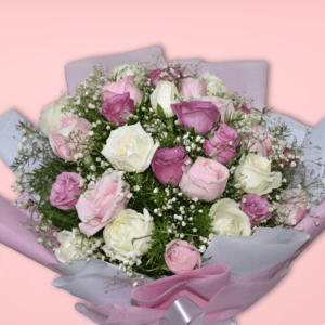 Elegant bouquet of pink, purple, and white roses wrapped in soft pink paper with a silver ribbon, perfect for special occasions.