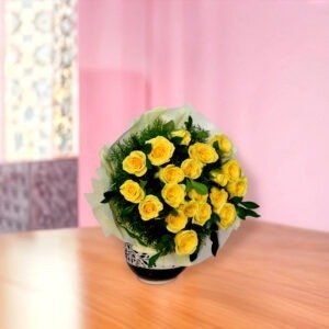 Vibrant bouquet of 20 yellow roses with greenery in black and white vase