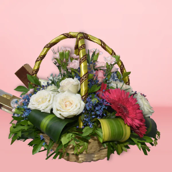 Flower basket with red gerberas, pink roses, white carnations, and Ferrero Rocher chocolates on a pink background.