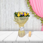 Gulmahal bouquet with yellow roses and purple flowers in cream wrapping