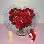 Heart-shaped vase filled with red roses and baby's breath, created by Hyderabad florist