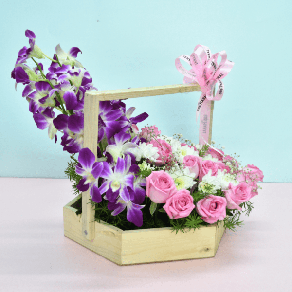 Flower basket with pink roses, white blooms, purple orchids, and a pink teddy bear for gifting in Hyderabad.