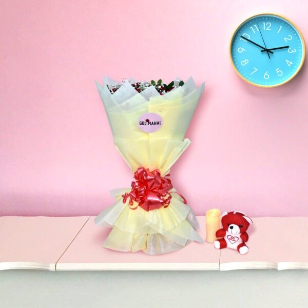 A bouquet of fresh red roses with baby's breath wrapped in cream paper, displayed against a pink background.