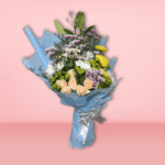 Mixed flower bouquet with yellow chrysanthemums, peach roses, white and purple carnations, wrapped in blue paper on a pink background.