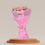 A bouquet of soft pink roses surrounded by baby's breath and greenery, wrapped in a pink paper with a delicate bow.