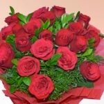 Luxurious bouquet of 20 red roses with green foliage in red wrapping