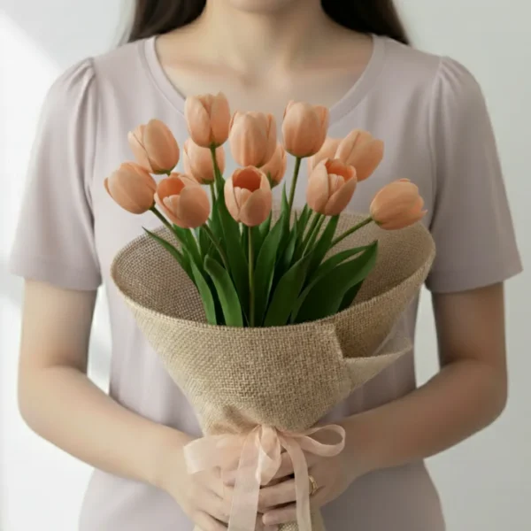 Peach tulip flowers wrapped and held in hands by a girl