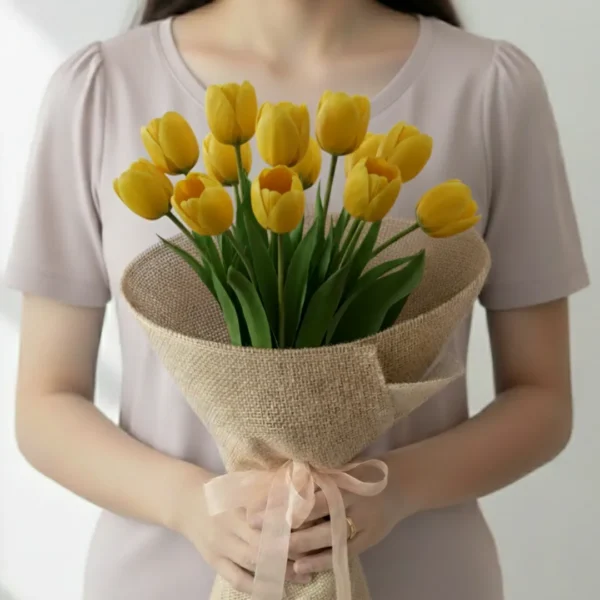Yellow tulip flowers wrapped and held in hands by a girl