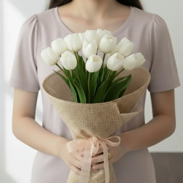 White tulip flowers wrapped and held in hands by a girl