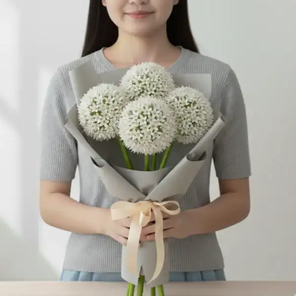 White Alliums wrapped and held in hands by a girl