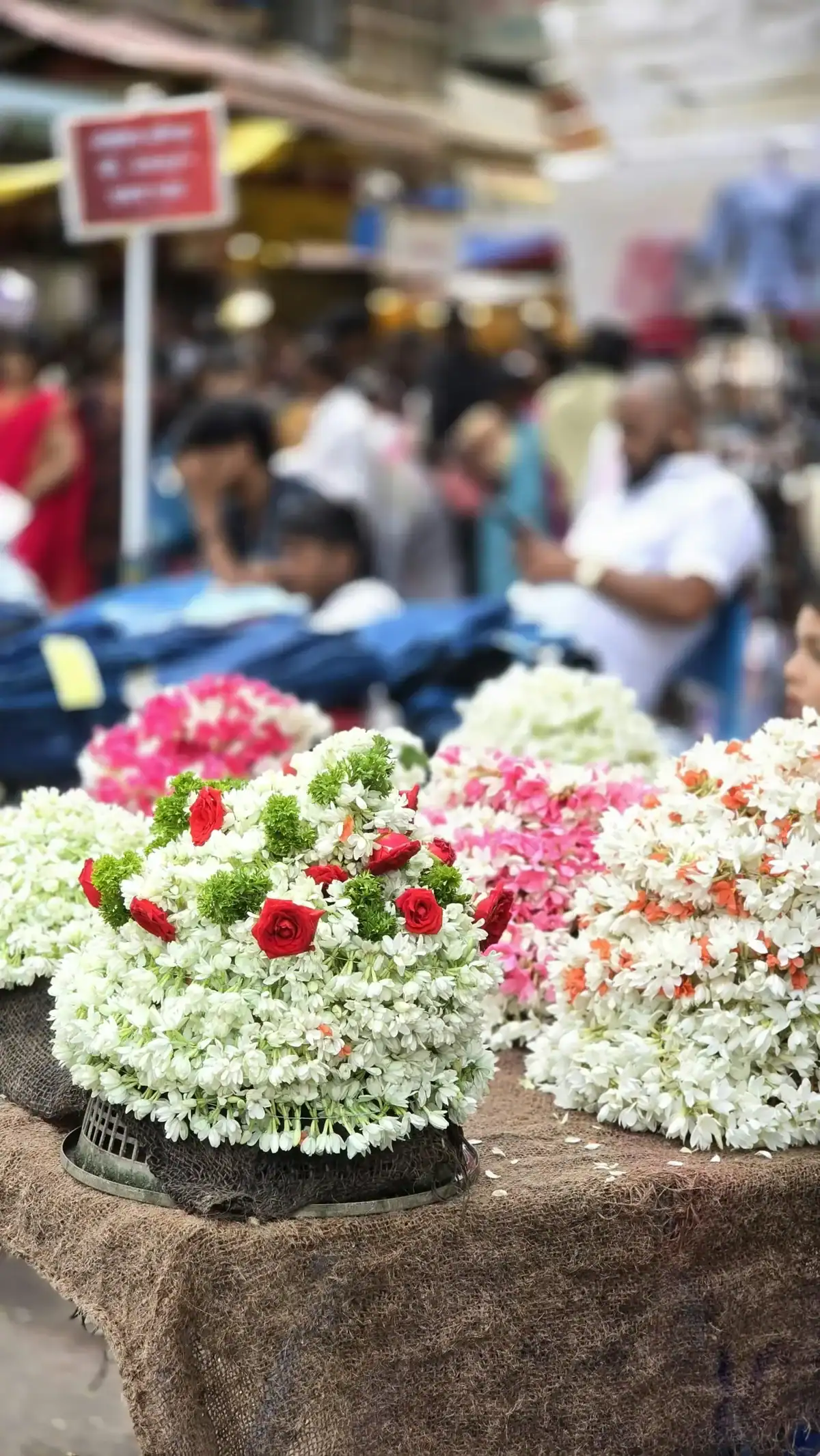 Fresh jasmine flower garlands with red roses at traditional Indian flower market, handcrafted floral arrangements for weddings, pooja décor and festive celebrations, authentic local flower market 