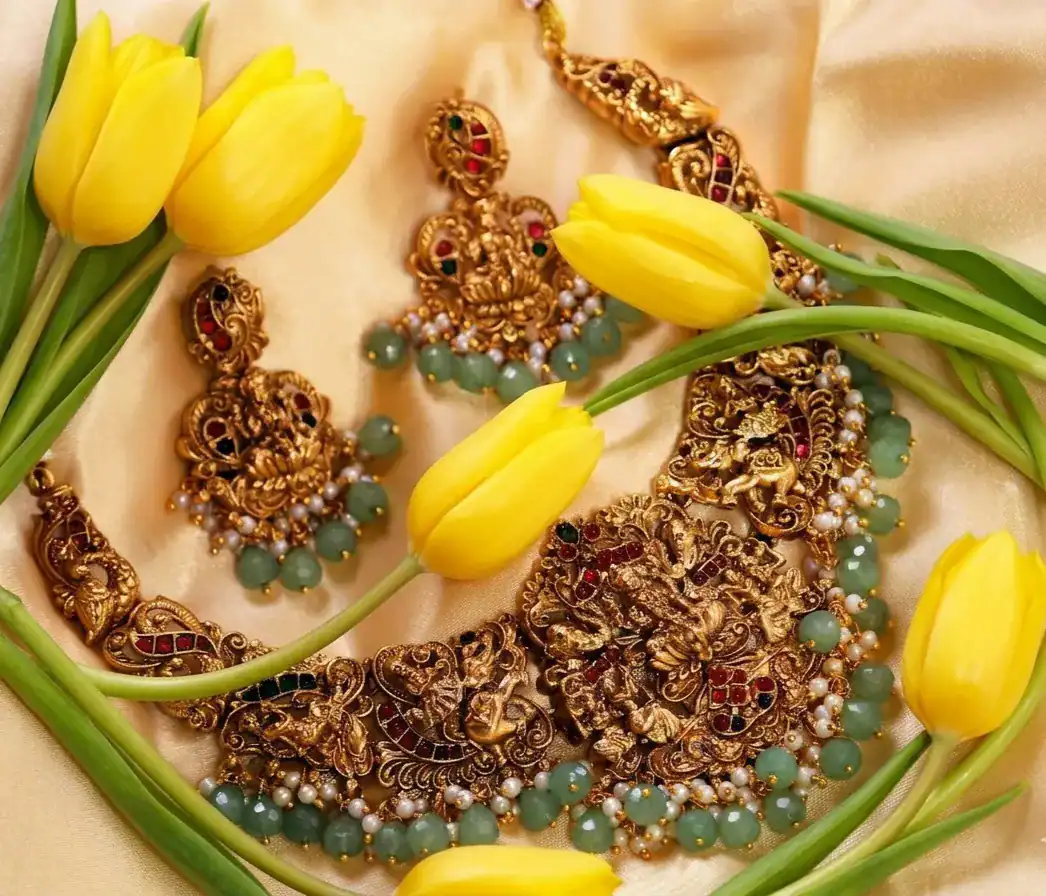 Yellow tulips with traditional gold bridal jewelry on silk fabric, elegant floral and jewelery flat lay